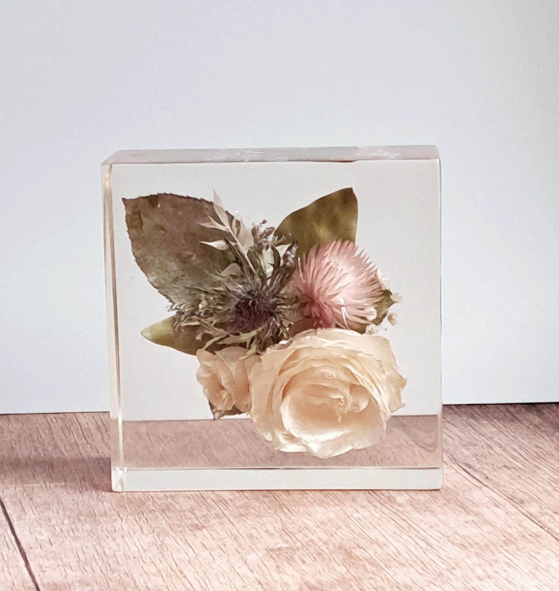 Rechteck aus 15x15x5 cm Epoxidharz mit eingearbeiteten Blumen aus dem eigenen Brautstrauß.
